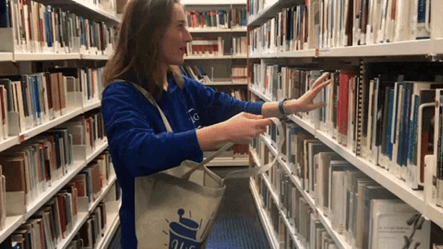 A woman surrounded by bookshelfs filling her bag with books very fast